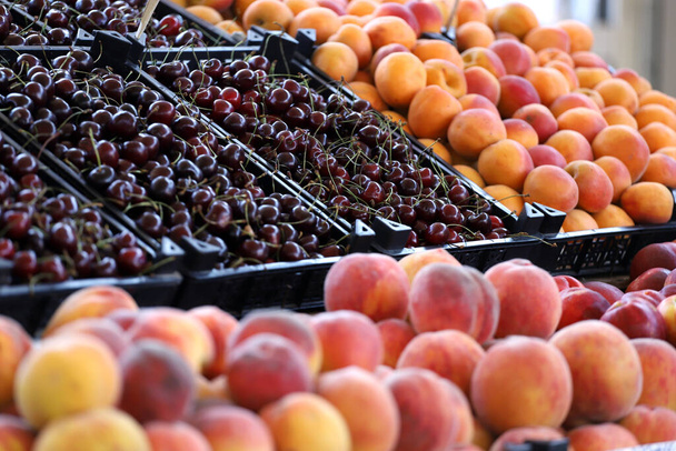 Kirsikoita, persikoita, nektariineja ja aprikooseja markkinoilla. Hedelmät kuvio - Valokuva, kuva