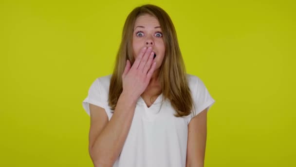 Geschokt vrouw sluit mond met de hand, kijkt in verrassing op de camera - Video