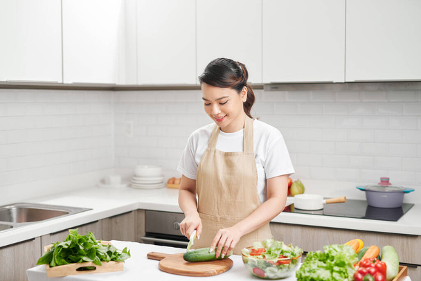 Frau schneidet Gemüse in der Küche - Foto, Bild