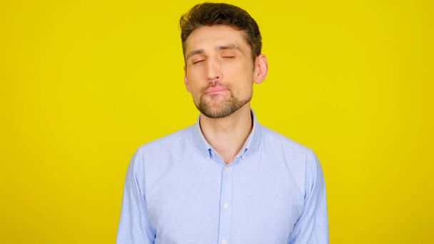 Man flirts licking lips with teeth on a yellow background with copyspace - Photo, Image