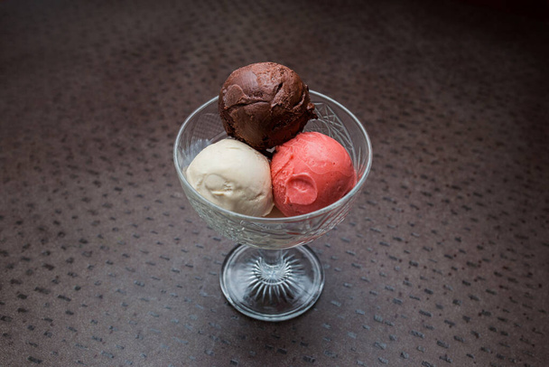 три шарика мороженого в стеклянной банке. вид сверху крупным планом. шоколад и сливки
 - Фото, изображение