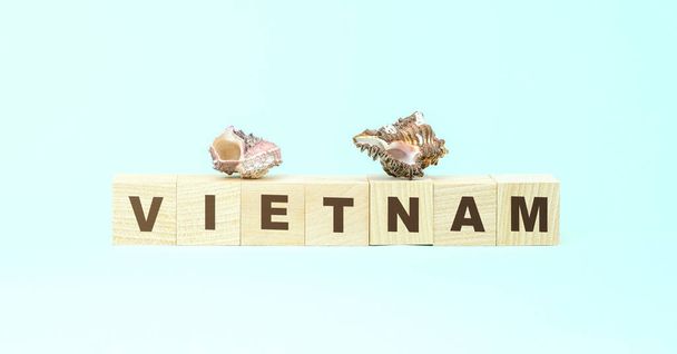 word Vietnam with wooden blocks and seashells on turquoise - 写真・画像