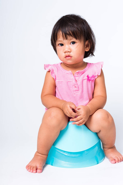Asian little cute baby child girl education training to sitting on blue chamber pot or potty in, studio shot isolated on white background, wc toilet concept - Photo, Image