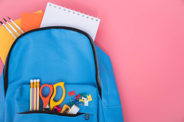 Top view flat lay of blue school bag backpack and accessories tools for children education on pink background, Back to school concept and have copy space for use - Foto, Imagem