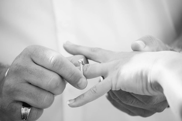 casal apaixonado de mãos dadas e se casar com anéis na cerimônia de casamento, foto em preto e branco
 - Foto, Imagem