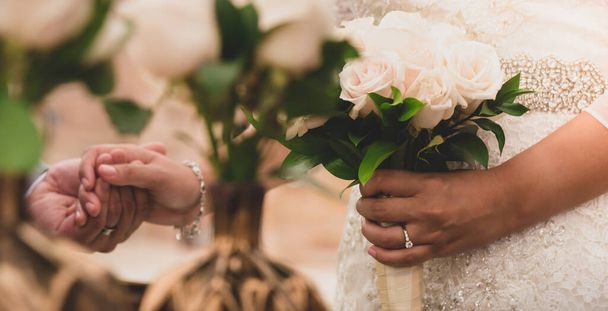 wunderschönes Hochzeitskleid auf Braut, Frau mit Blumenstrauß und neben Bräutigam stehend  - Foto, Bild