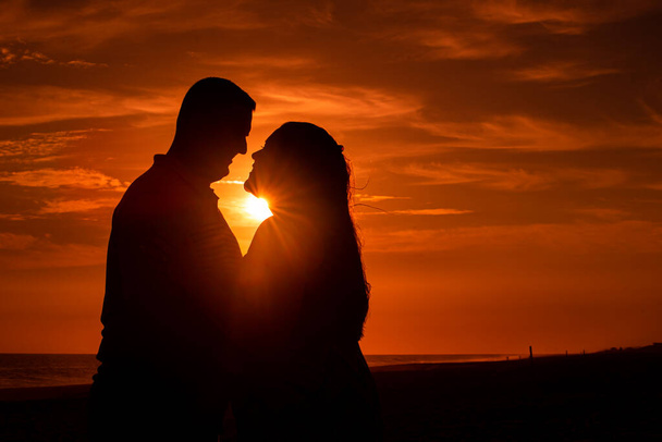 couple in love against bright red sunset sky  - Photo, Image