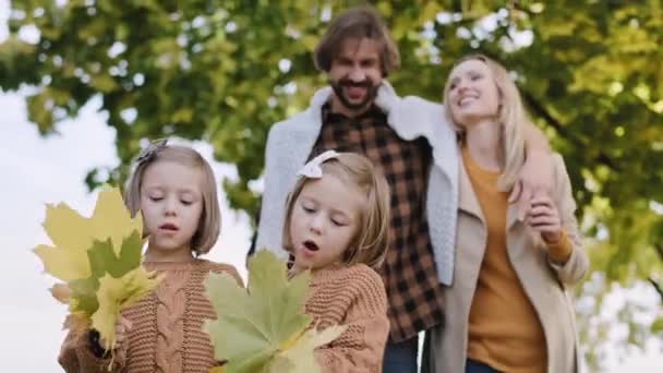 Handheld pohled na šťastnou rodinu během podzimní procházky - Záběry, video