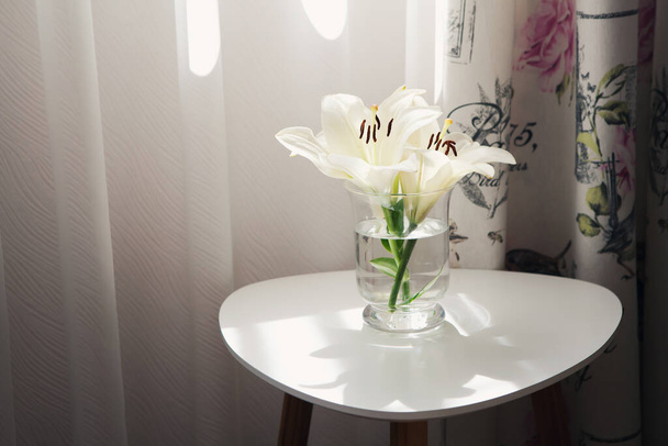 Lily flowers in vase on white table with copy space - Foto, Imagen