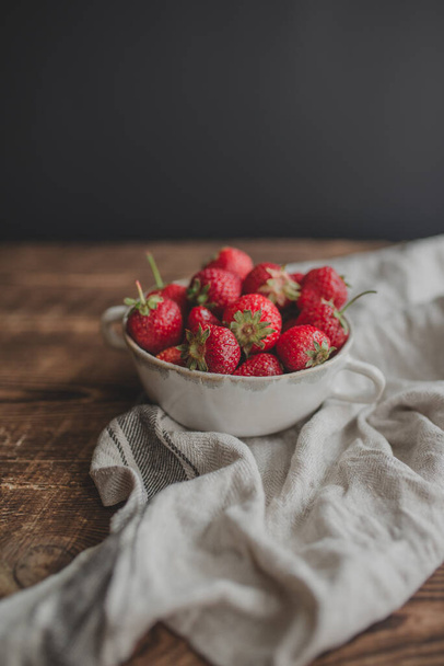 Plate with fresh strawberries on a wooden background. - Fotografie, Obrázek
