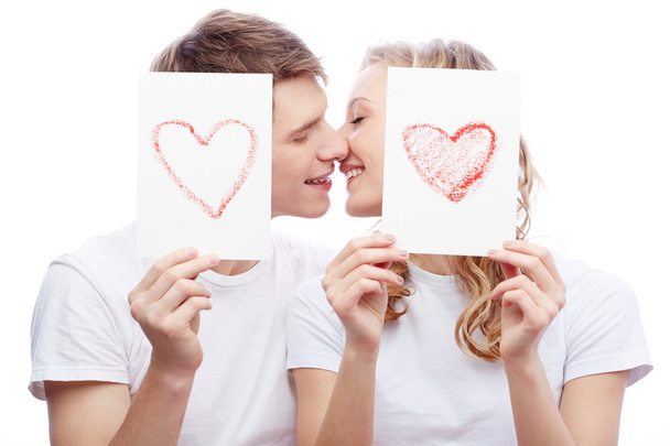 Casal beijando enquanto segurando papéis com corações
 - Foto, Imagem