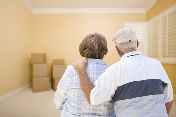 Couple âgé dans la chambre regardant les boîtes de déménagement sur le sol
 - Photo, image
