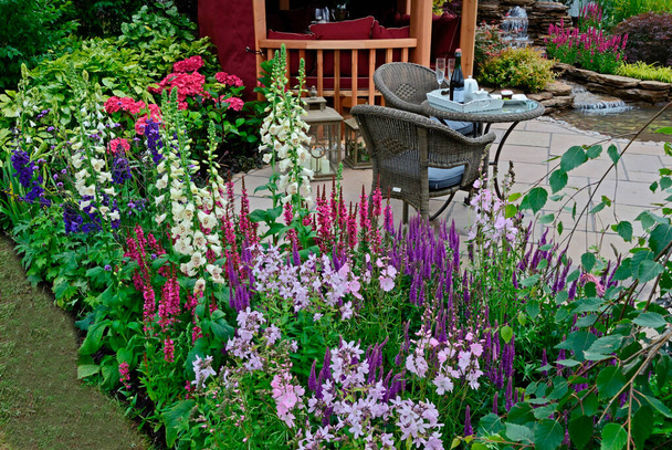 La zona patio e terrazza nel giardino acquatico con bordo colorato fiore e casa estiva - Foto, immagini