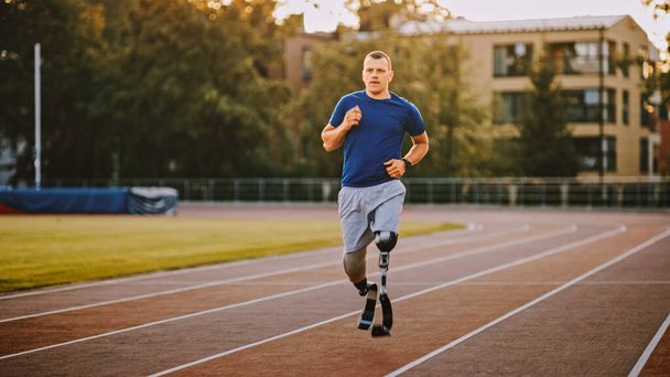 Atletický zdravotně postižený muž s protetické běžecké čepele je trénink na venkovním stadionu za slunečného odpoledne. Amputovaný běžec na Stadionové dráze. Motivační sportovní snímek. - Fotografie, Obrázek