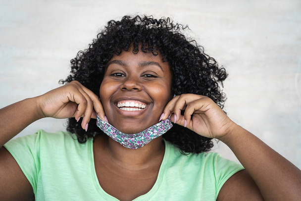 Happy Afro vrouw portret - Afrikaans meisje dragen gezichtsmasker glimlachen voor de camera - Gezondheidszorg en corona virus uitbraak concept - Foto, afbeelding