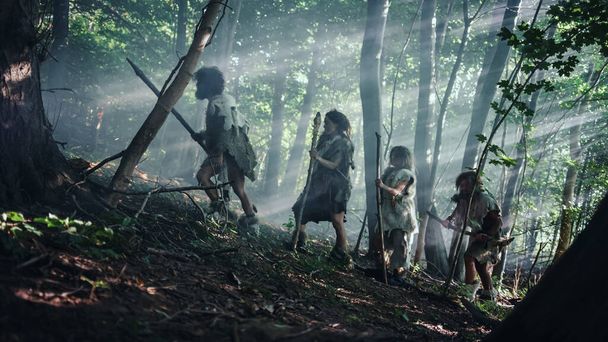 Tribe of Hunter-Gatherers Wearing Animal Skin Holding Stone Tipped Tools, Explore Prehistoric Forest in a Hunt for Animal Prey. Neanderthal Family Hunting in the Jungle or Migrating for Better Land - Foto, Imagen