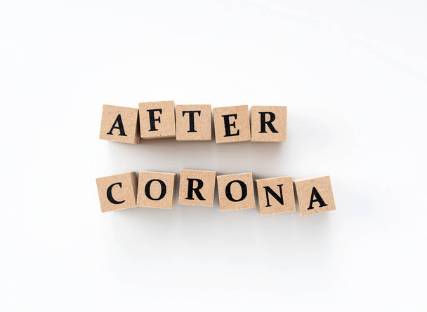 Un bloque de madera con la palabra After Corona escrita sobre un fondo blanco
 - Foto, Imagen