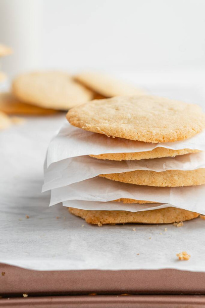 A vertical shot of a stack of homemade cookies with white napkins on a tray - Фото, зображення