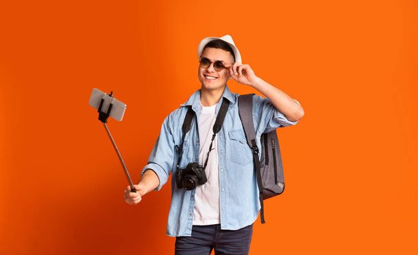 Fiatal férfi utazó szemüveggel pozitív szelfit készít - Fotó, kép