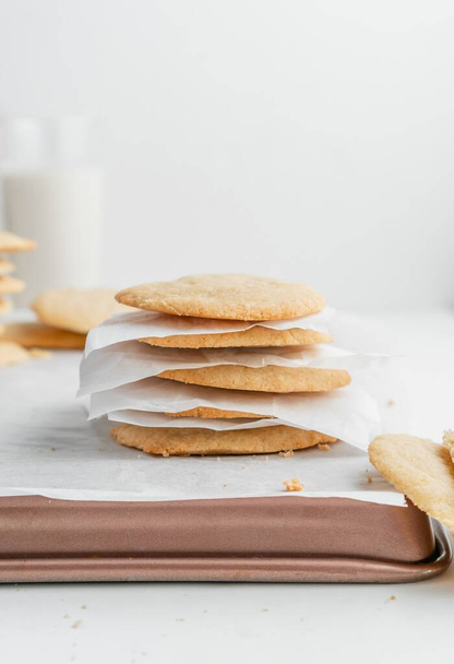 A vertical shot of a stack of homemade cookies with white napkins on a tray - Foto, Imagen