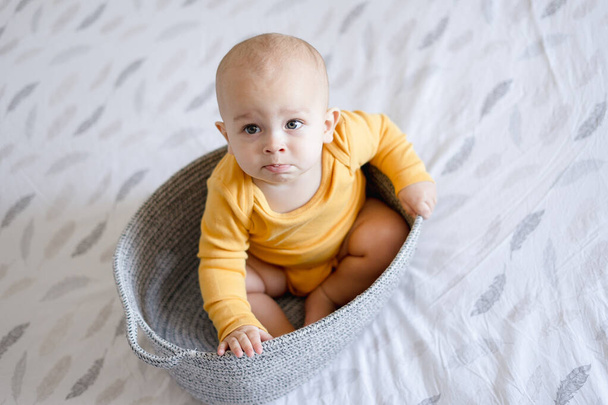 confused toddler boy in a basket - Zdjęcie, obraz