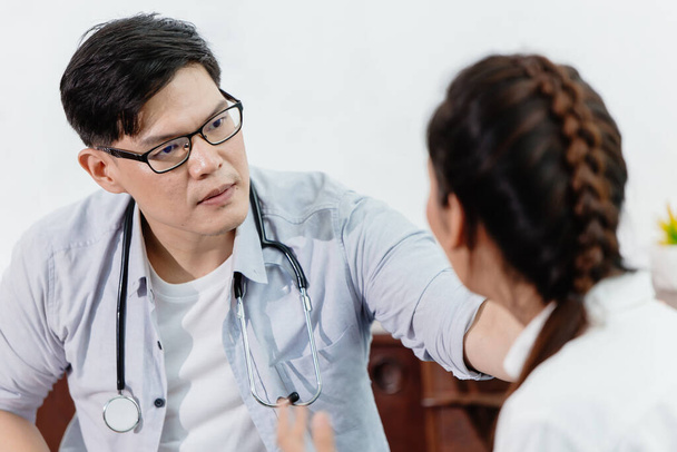 Orvos komoly megjelenés és hallgatás vigasztaló női beteg magyarázó tünetek és kezelés, hogy ő jobban érzi magát. - Fotó, kép