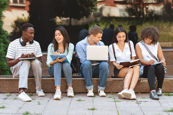 Group of happy teen high school students studying outdoors - Photo, Image