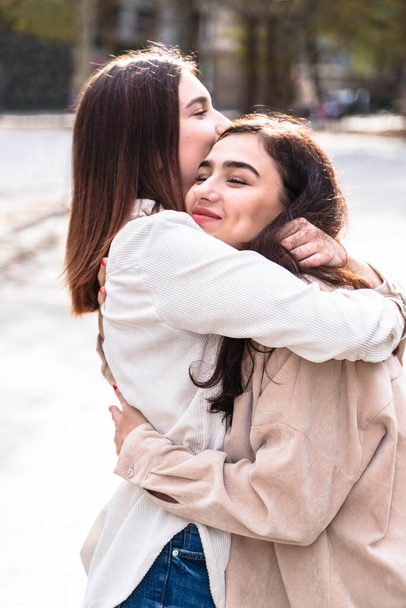 Meeting of two girls friends with hug in city - Φωτογραφία, εικόνα