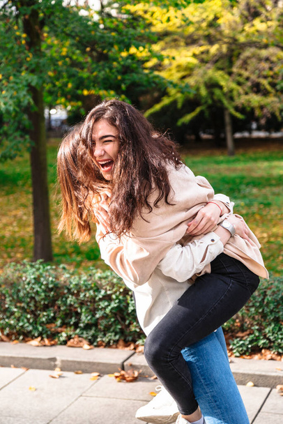 Girl hugs her best friend tightly in park outdoor - Fotoğraf, Görsel