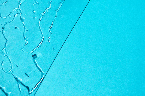Rozpryski i przepływ szkła cienia wody odbicie na niebieskim tle z miejsca do kopiowania. Krople deszczu mokra tekstura - Zdjęcie, obraz