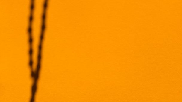 Japa kralen schaduwen op saffraan pastelpapier. Een abstracte rug. Voorraadfotografie. - Foto, afbeelding