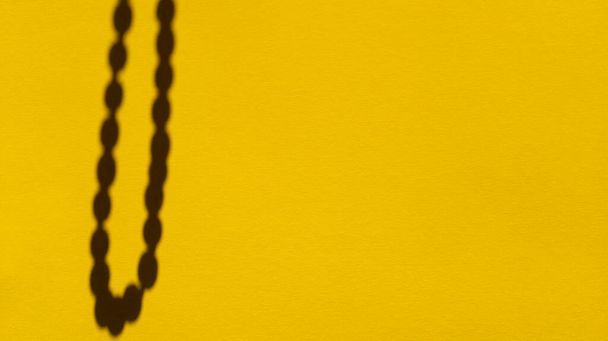 Japa gyöngyök árnyékok sárga pasztell papíron. Absztrakt backgorund. Készletfotózás. - Fotó, kép