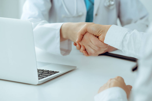 Doctor and patient shaking hands, close-up. Medicine, healthcare and trust concept - Fotografie, Obrázek