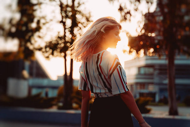 Attractive blonde girl smiling at sunset. Happy Hipster lifestyle - 写真・画像