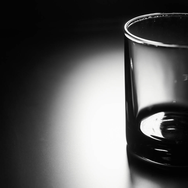 Quadrado foto preto e branco de vidro vazio em um fundo preto fosco com luz de fundo
 - Foto, Imagem
