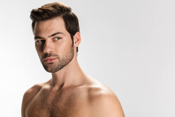 Photo of unshaven half-naked man posing and looking aside isolated over white background - Foto, Imagen