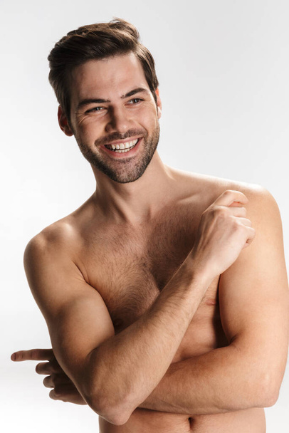 Photo of joyful half-naked man smiling and looking aside isolated over white background - Фото, изображение