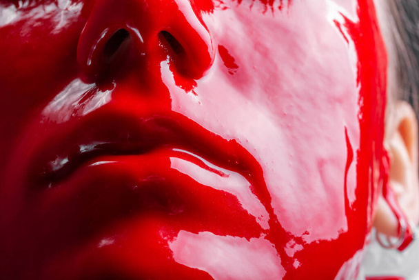 Фото женского лица с глянцевой красной краской
 - Фото, изображение