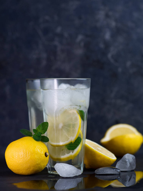 Due bicchieri di rinfrescante limonata estiva alla menta al limone sul tavolo nero - Foto, immagini