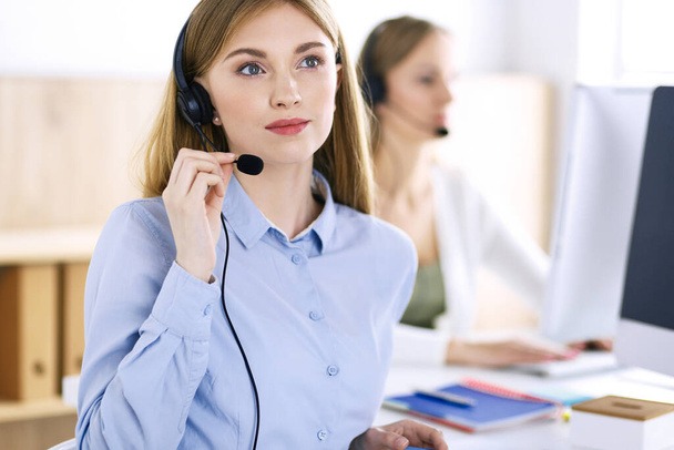 Portrait of call center operator at work. Group of people in a headset ready to help customers. Business concept - Fotoğraf, Görsel