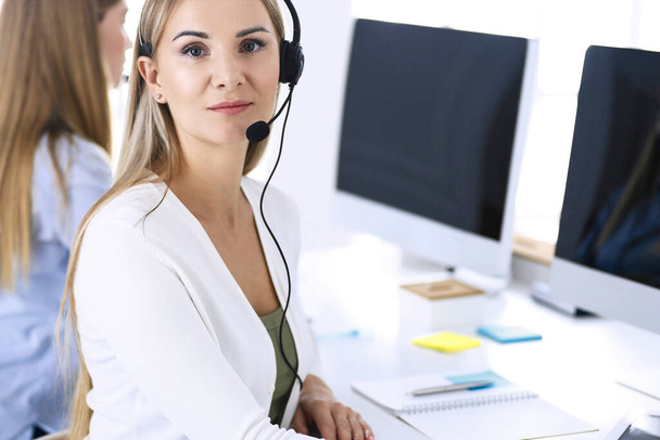 Portrait of call center operator at work. Group of people in a headset ready to help customers. Business concept - Фото, изображение