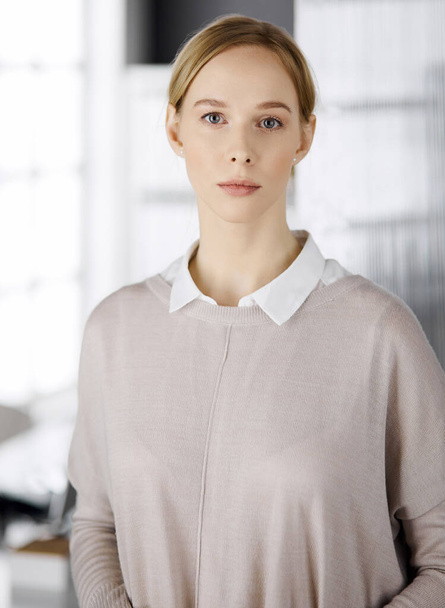 Friendly adult casual dressed business woman standing straight. Concept of a business headshot or portrait in office - Foto, afbeelding