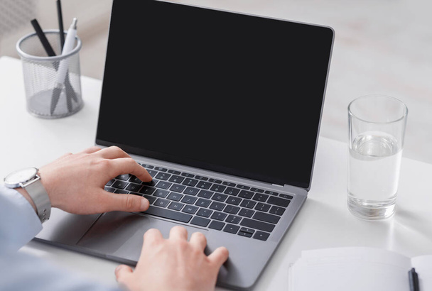 Handen van zakenman werken op laptop met blanco scherm - Foto, afbeelding