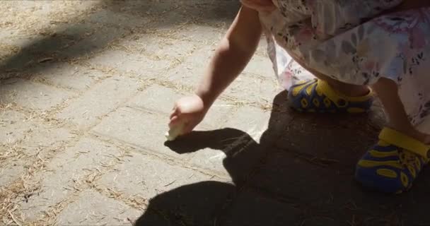 Dziewczyna rysować kredkami na ziemi w parku - Materiał filmowy, wideo