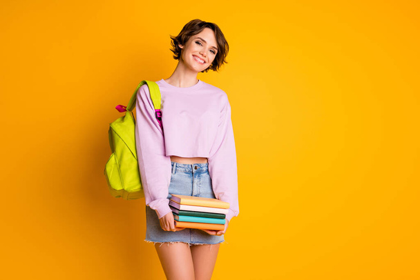 Portrait of positive cheerful academic high school student girl ready study lesson lectures hold pile stack textbook wear sweater bag isolated over bright shine color background - Foto, immagini