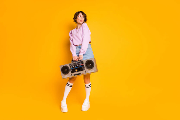 Full length body size view of her she nice attractive lovely girlish funny dreamy shy girl carrying boombox having fun pout lips posing isolated on bright vivid shine vibrant yellow color background - Photo, Image