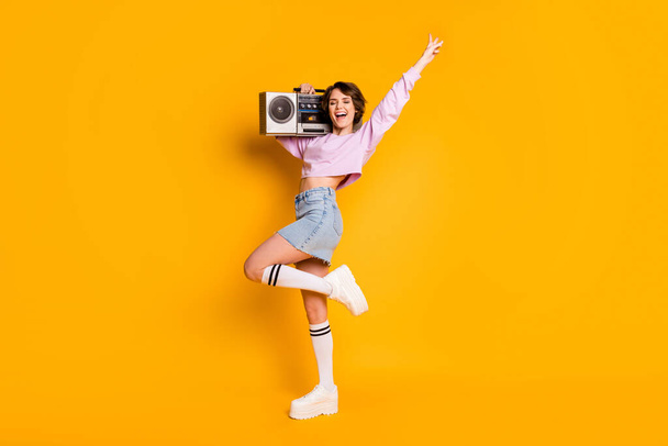 Full length body size view of her she nice attractive lovely cheerful funny girl carrying boombox having fun dancing retro vintage trend isolated on bright vivid shine vibrant yellow color background - Foto, Imagen