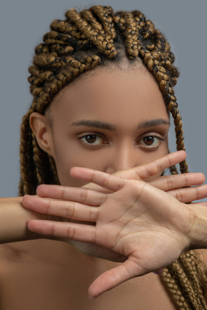 Sad young African American woman closing her mouth with crossed hands, showing her palms to camera - Foto, Imagen