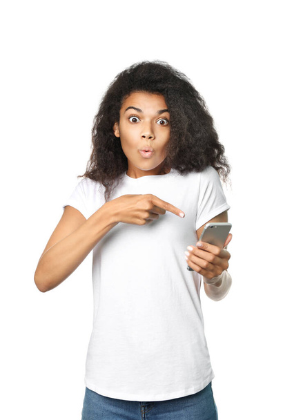 Belle femme africaine tenant un téléphone dans sa main isolé sur fond blanc - Photo, image
