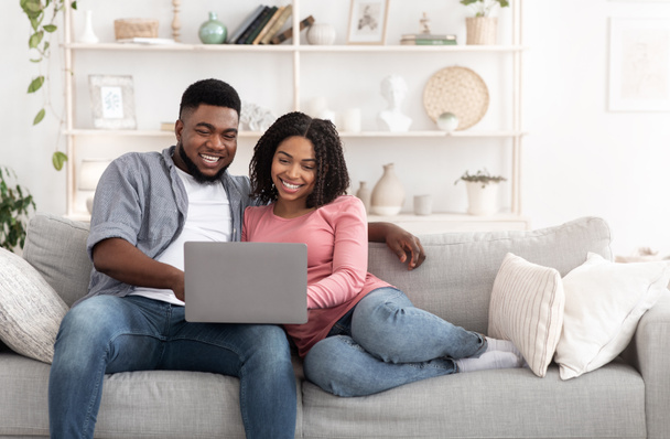 Weekend Passtime. Married Afro Couple Using Laptop At Home Together, Watching Movies - Photo, Image